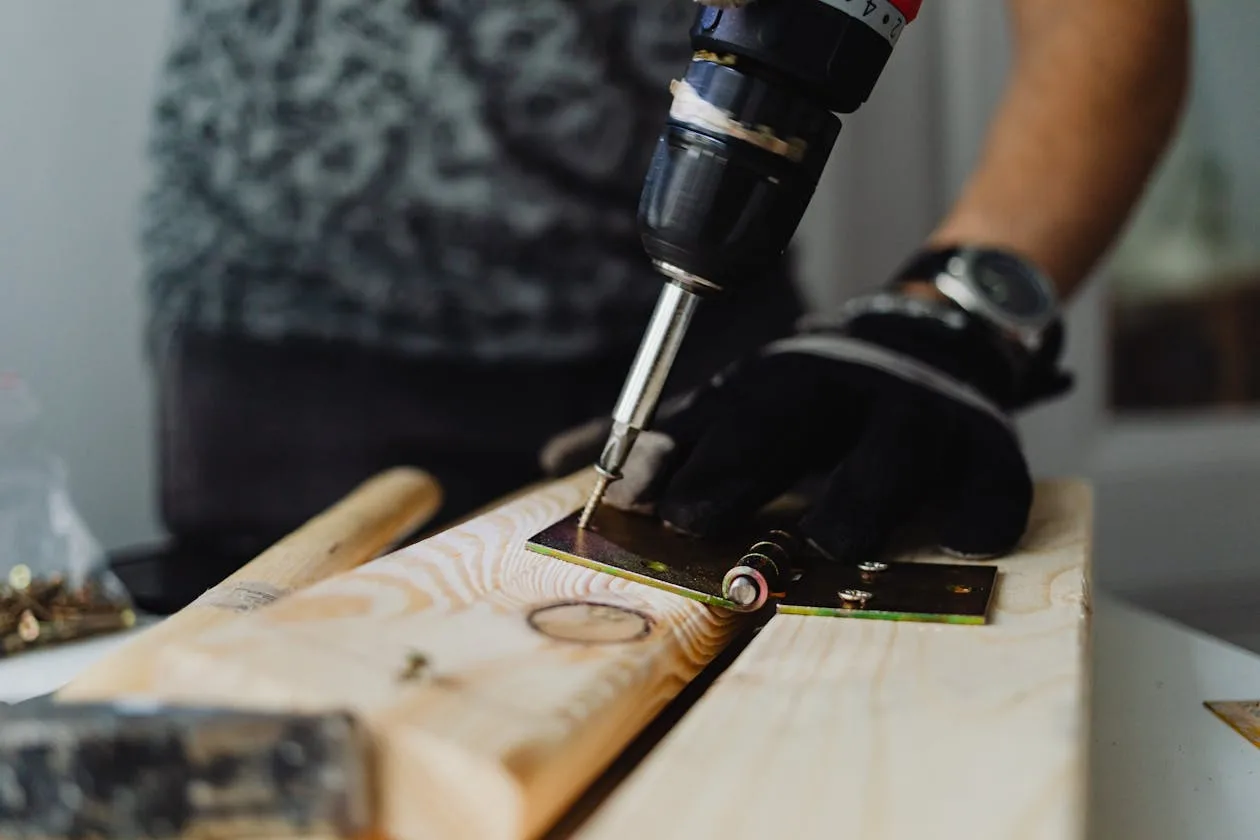 Phoenix handyman driving a screw into a wooden bracket during a home repair after being matched with the homeowner through the exclusive handyman leads system.