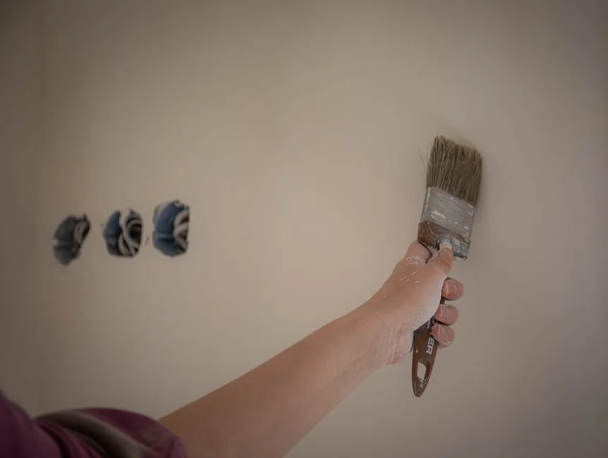 Phoenix painter applying a brush stroke to an interior wall during a residential paint job after being matched through the exclusive painting leads network.