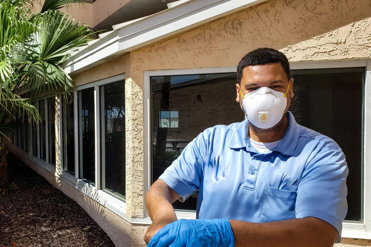 Hornet nest removal pro in protective gear outside a Phoenix, Arizona home, ready to treat an active nest.
